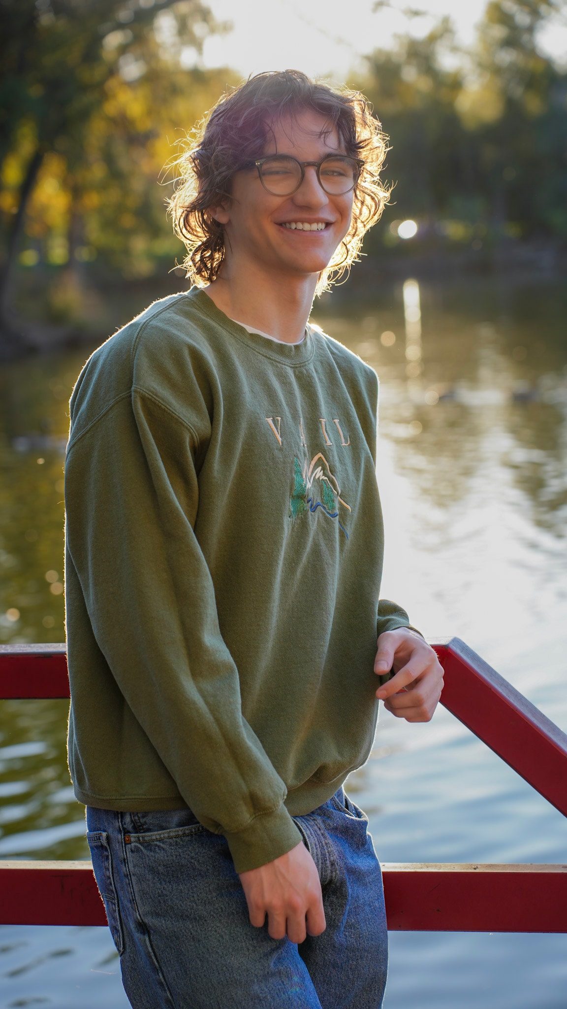 Senior portrait by the water at golden hour