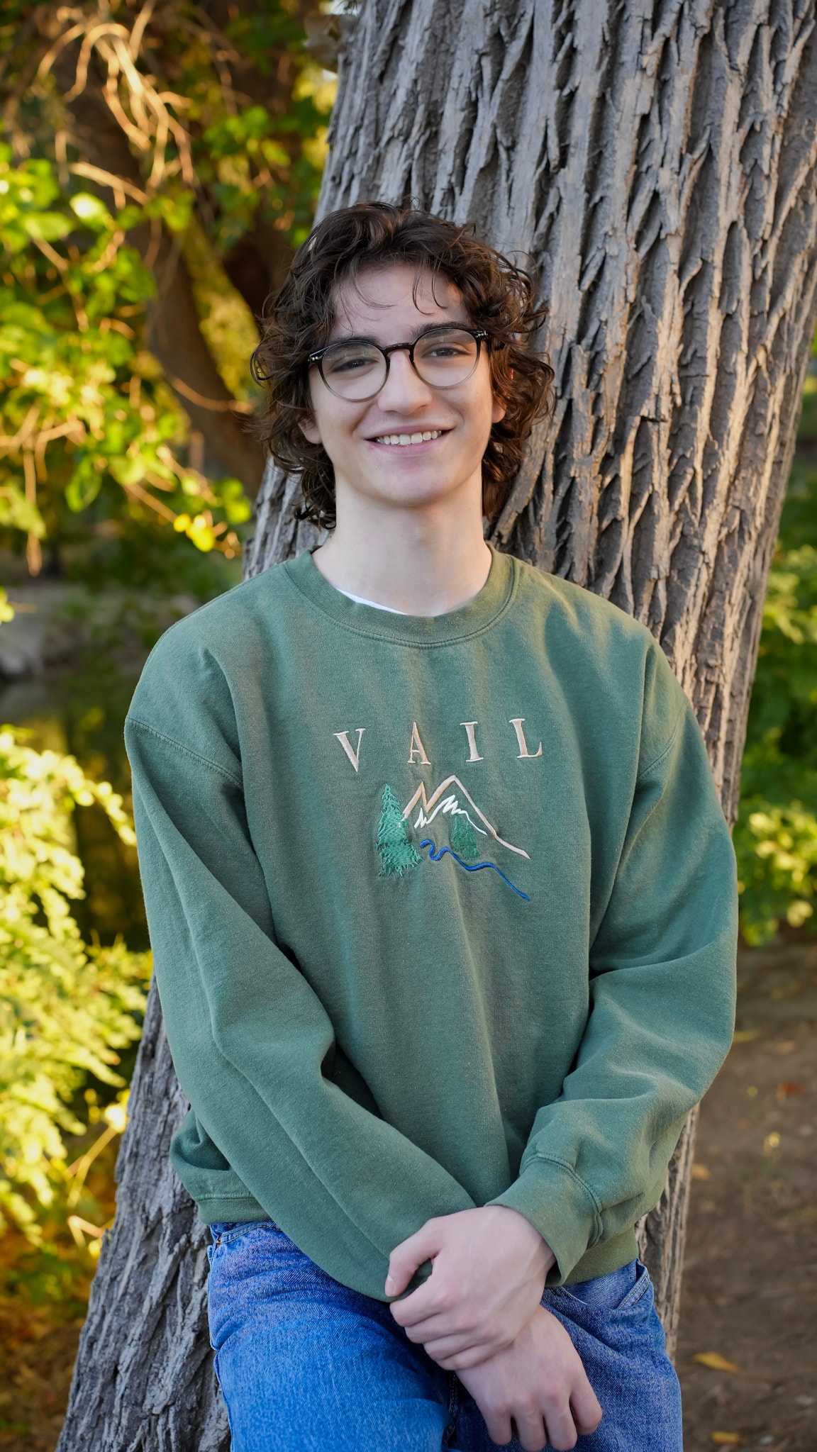Senior portrait leaning against tree